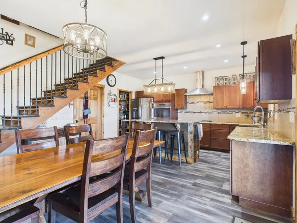 a view of dining room and livingroom with furniture wooden floor a chandelier