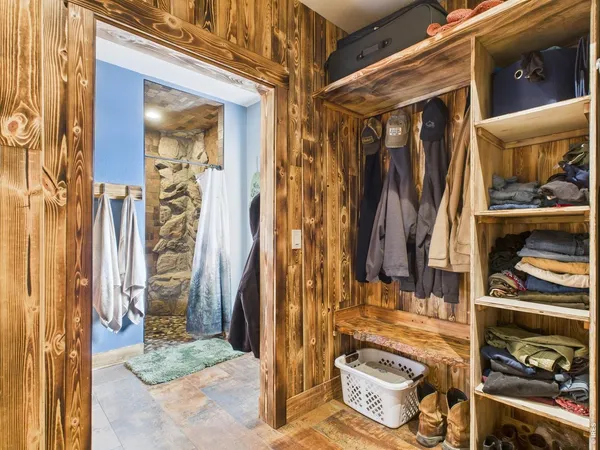 a view of walk in closet with clothes and shoes