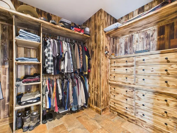 a view of walk in closet with clothes and shoes
