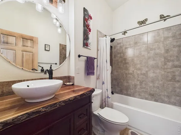 a bathroom with a granite countertop sink toilet a mirror and shower