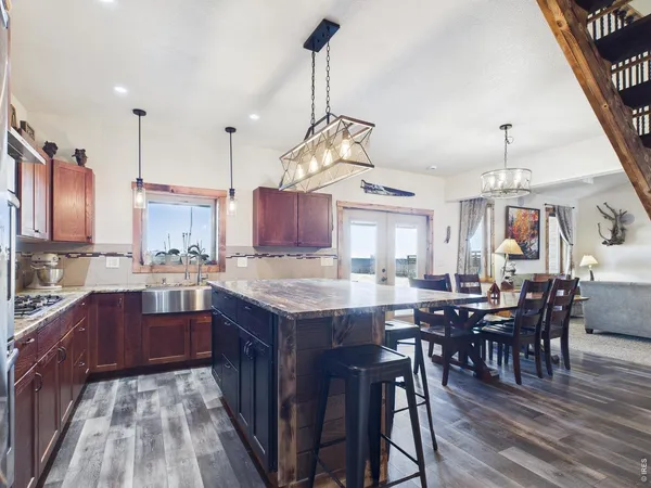 a kitchen with stainless steel appliances granite countertop kitchen island wooden cabinets and dining table