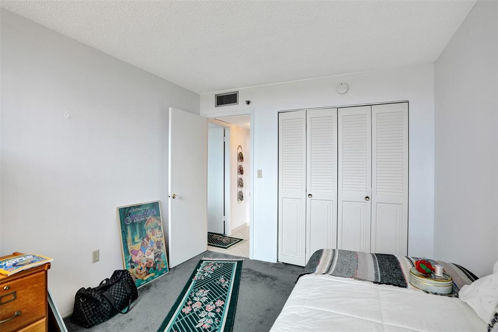 1100 St Charles Place, Unit 612 Pembroke Pines, FL 33026 - Photo 27 of 71 a bedroom with furniture and a rug