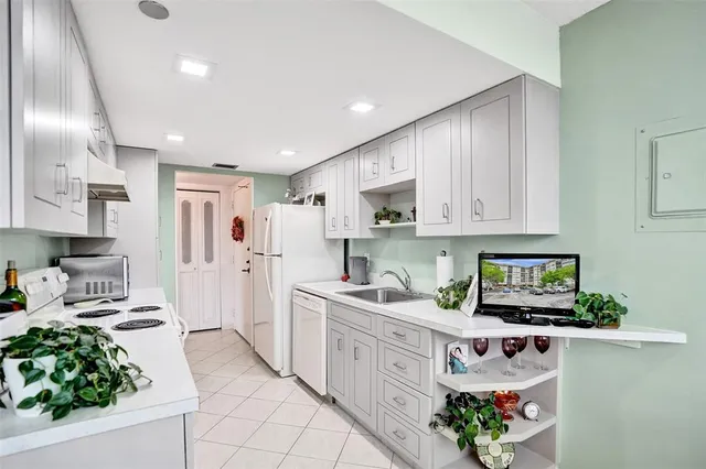 a kitchen with stainless steel appliances granite countertop white cabinets a stove top oven a sink and dishwasher