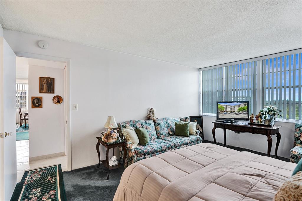 1100 St Charles Place, Unit 612 Pembroke Pines, FL 33026 - Photo 34 of 71 a bedroom with a bed and wooden floor