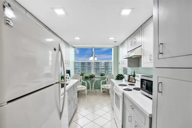 a kitchen with stainless steel appliances kitchen island granite countertop a stove and cabinets