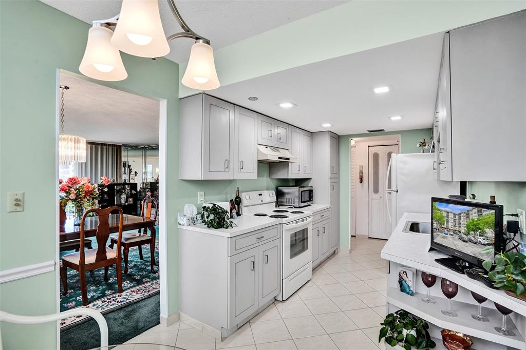 1100 St Charles Place, Unit 612 Pembroke Pines, FL 33026 - Photo 9 of 71 a kitchen with stainless steel appliances kitchen island granite countertop a stove and cabinets