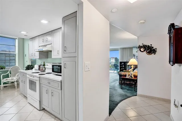 a dining room filled chandelier and kitchen view