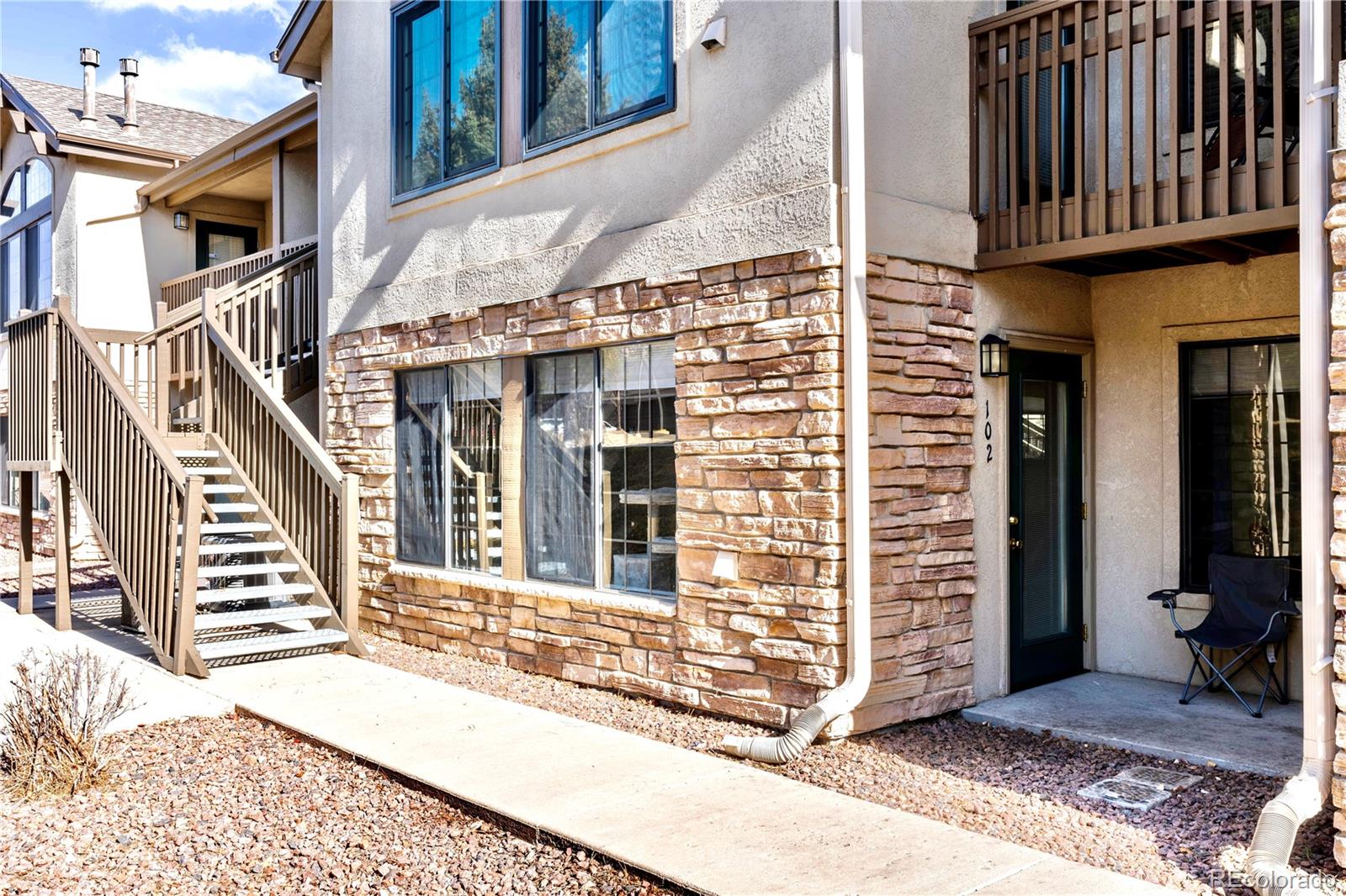2170 Alicia Point, Unit 102 Colorado Springs, CO 80919 - Photo 2 of 37 a view of a brick house with wooden walls and stairs