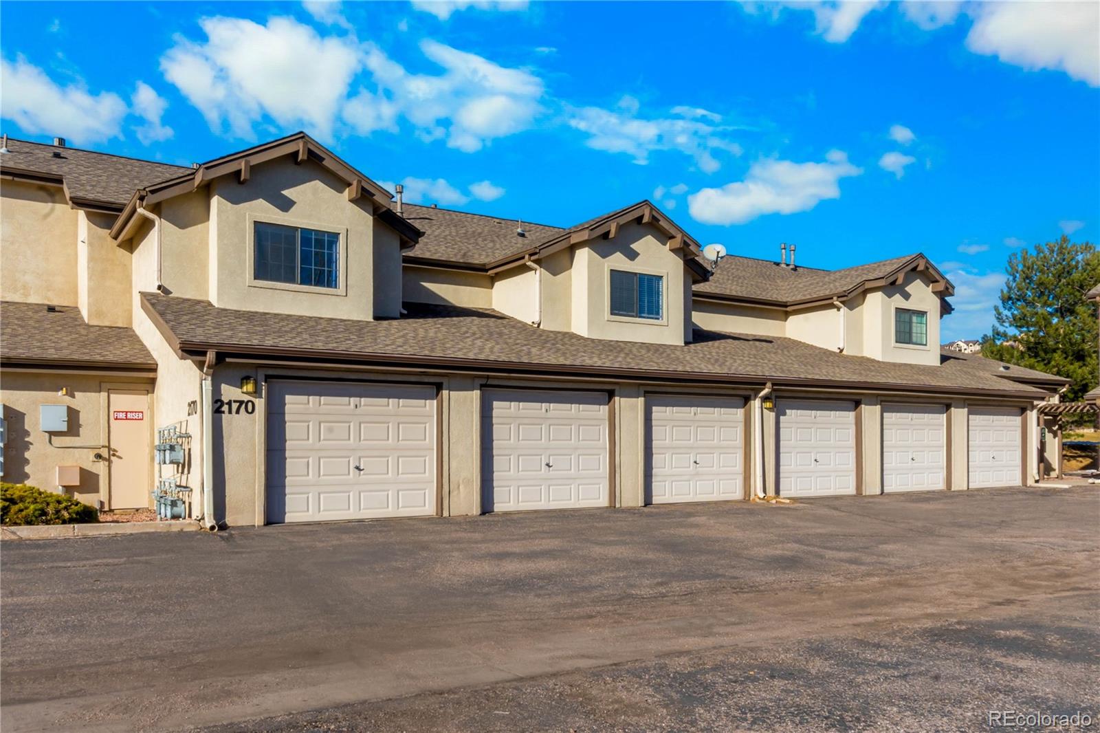 2170 Alicia Point, Unit 102 Colorado Springs, CO 80919 - Photo 24 of 37 a front view of a house with a yard and garage