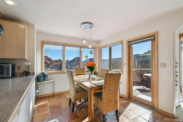 a dining room with furniture water view and a floor to ceiling window