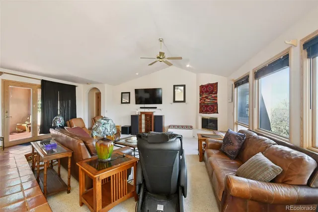 a living room with furniture ceiling fan and a window