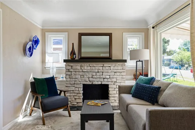 a living room with furniture fireplace and a large window