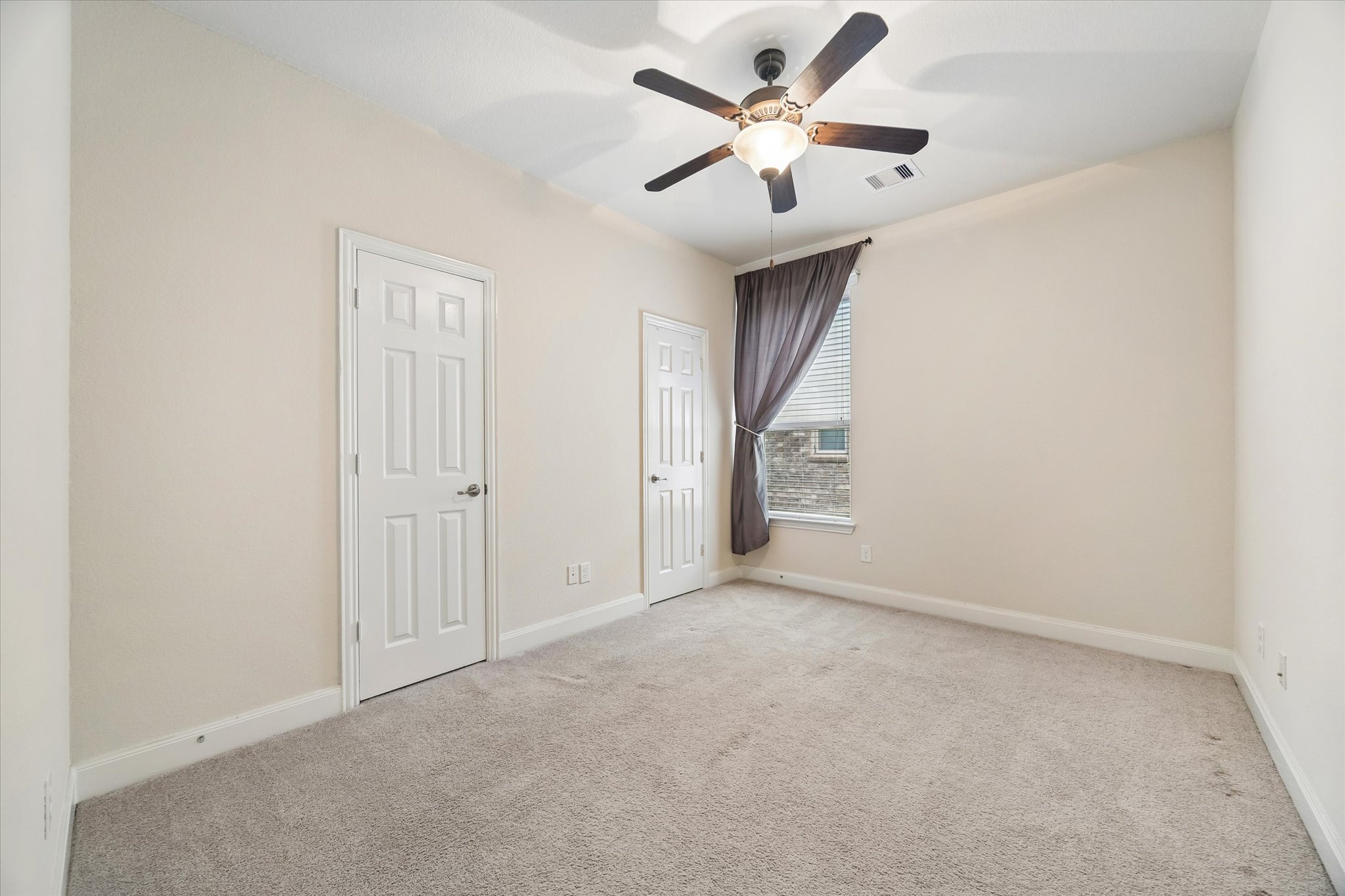 2214 Wembley Way Rosenberg, TX 77471 - Photo 30 of 35 Carpeted room featuring a vaulted ceiling with a fan light fixture, two panel doors, and a window with blinds and a curtain