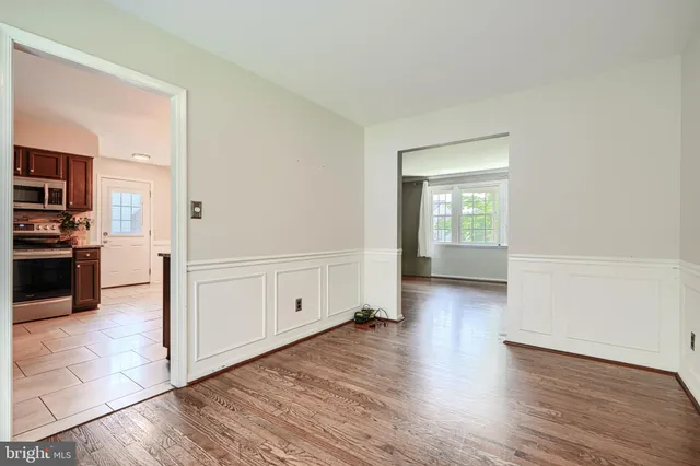 wooden floor in kitchen and empty room with wooden floor