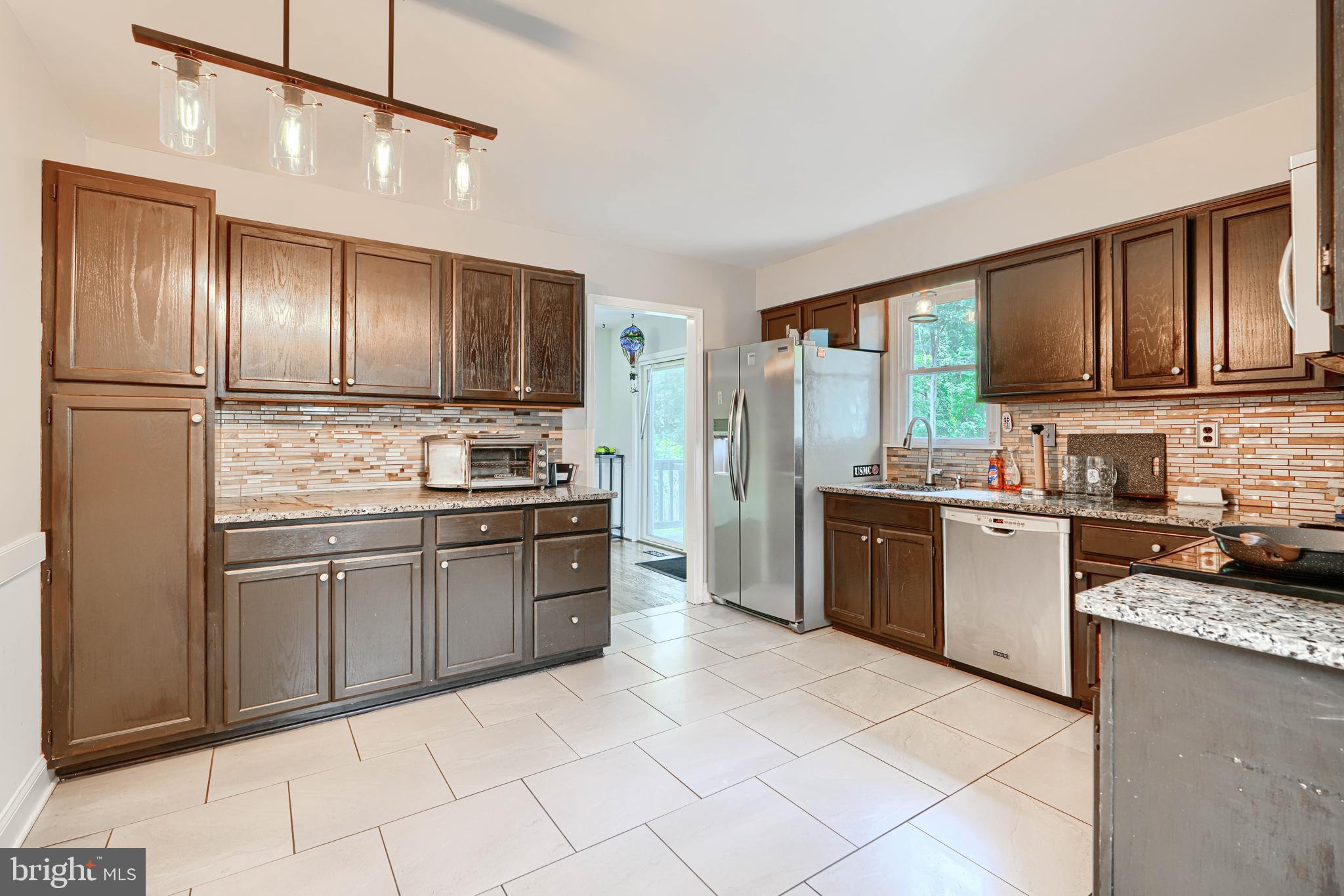 1353 Sweetbriar Lane Bel Air, MD 21014 - Photo 14 of 43 a large kitchen with granite countertop a stove refrigerator and cabinets