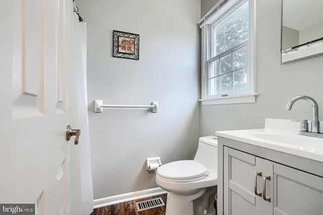 a bathroom with a sink mirror vanity and toilet