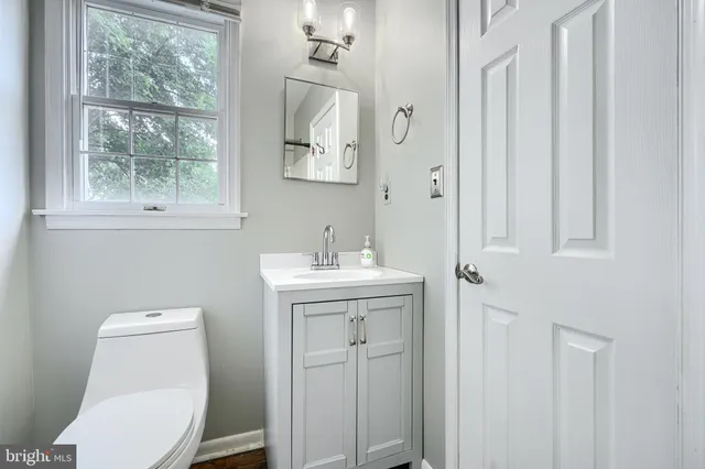a bathroom with a toilet a sink and mirror