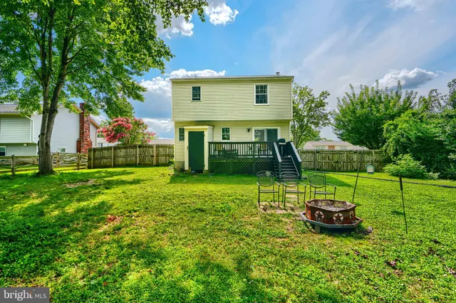 a view of a house with backyard and a tree