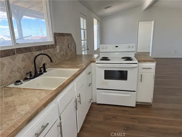 a view of a kitchen with sink a stove and microwave