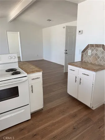 a kitchen with granite countertop white cabinets and white appliances