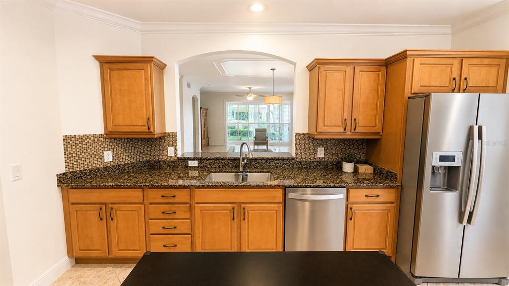 6552 Moorings Point Circle, Unit 102 Lakewood Ranch, FL 34202 - Photo 8 of 57 a kitchen with stainless steel appliances granite countertop a refrigerator a stove and a sink