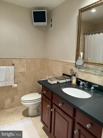 a bathroom with a granite countertop sink a toilet and a mirror