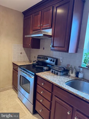 a kitchen with stainless steel appliances granite countertop a sink a stove and cabinets