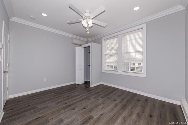 726 Howell Avenue, Unit B Riverhead, NY 11901 - Photo 5 of 7 an empty room with wooden floor and windows
