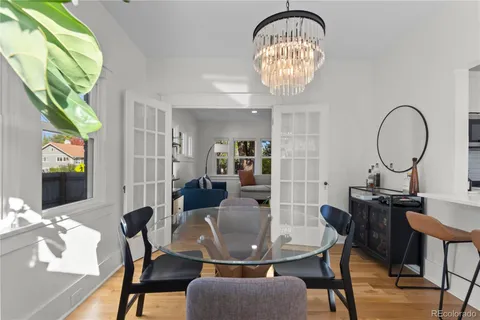 a view of a dining room with furniture a chandelier and wooden floor