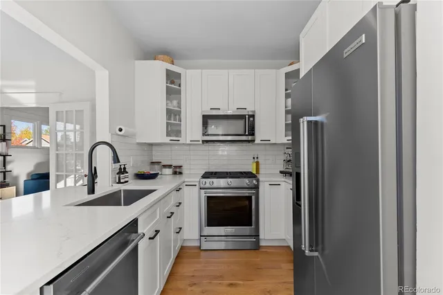 a kitchen with stainless steel appliances granite countertop a refrigerator sink and stove