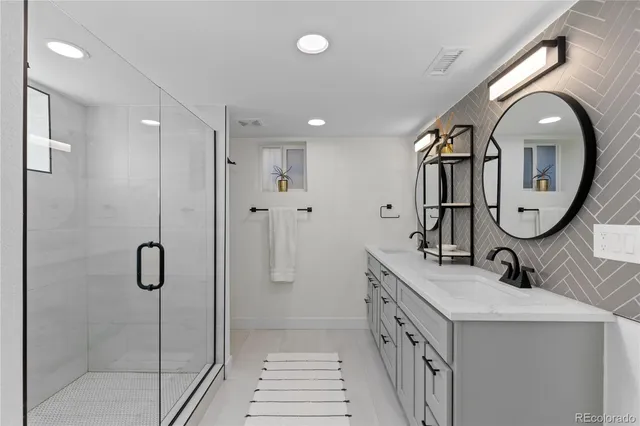 a bathroom with a double vanity sink mirror and shower