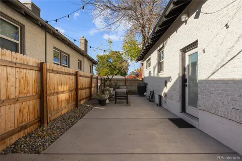 a view of a patio with table and chairs and wooden fence