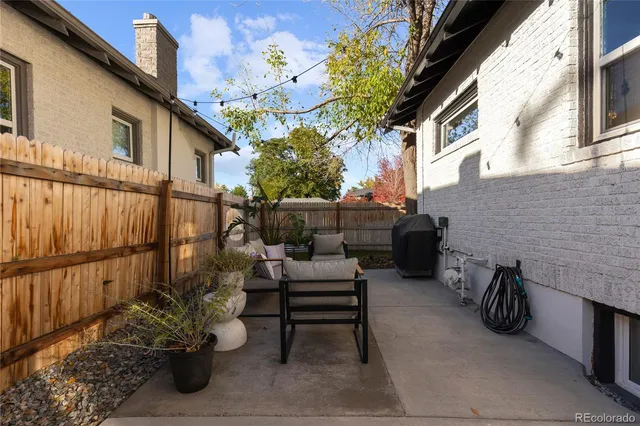 a view of a patio with a table and chairs and potted plants