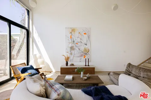 a living room with furniture and floor to ceiling windows