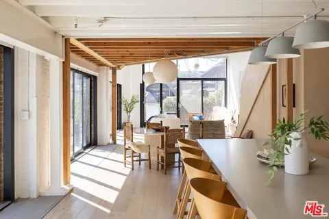 a dining room with wooden floor and furniture
