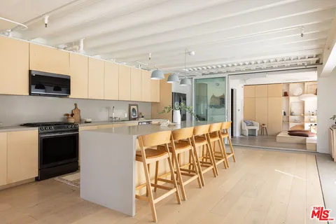 a kitchen with stainless steel appliances kitchen island granite countertop a refrigerator and a stove top oven