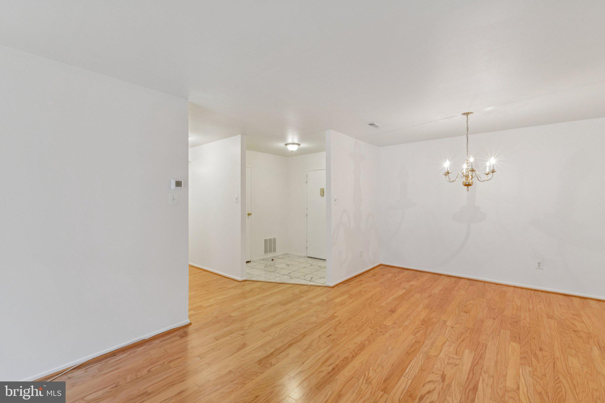 2817 Jermantown Road, Unit 108 Oakton, VA 22124 - Photo 11 of 20 a view of a room with wooden floor and a ceiling fan