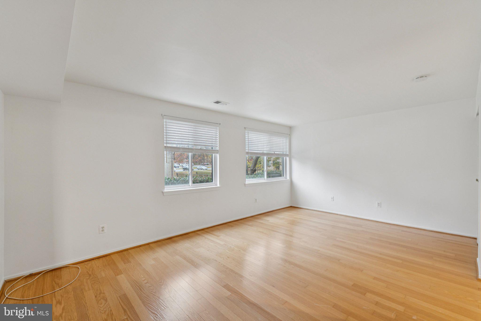 2817 Jermantown Road, Unit 108 Oakton, VA 22124 - Photo 12 of 20 a view of an empty room with wooden floor and a window