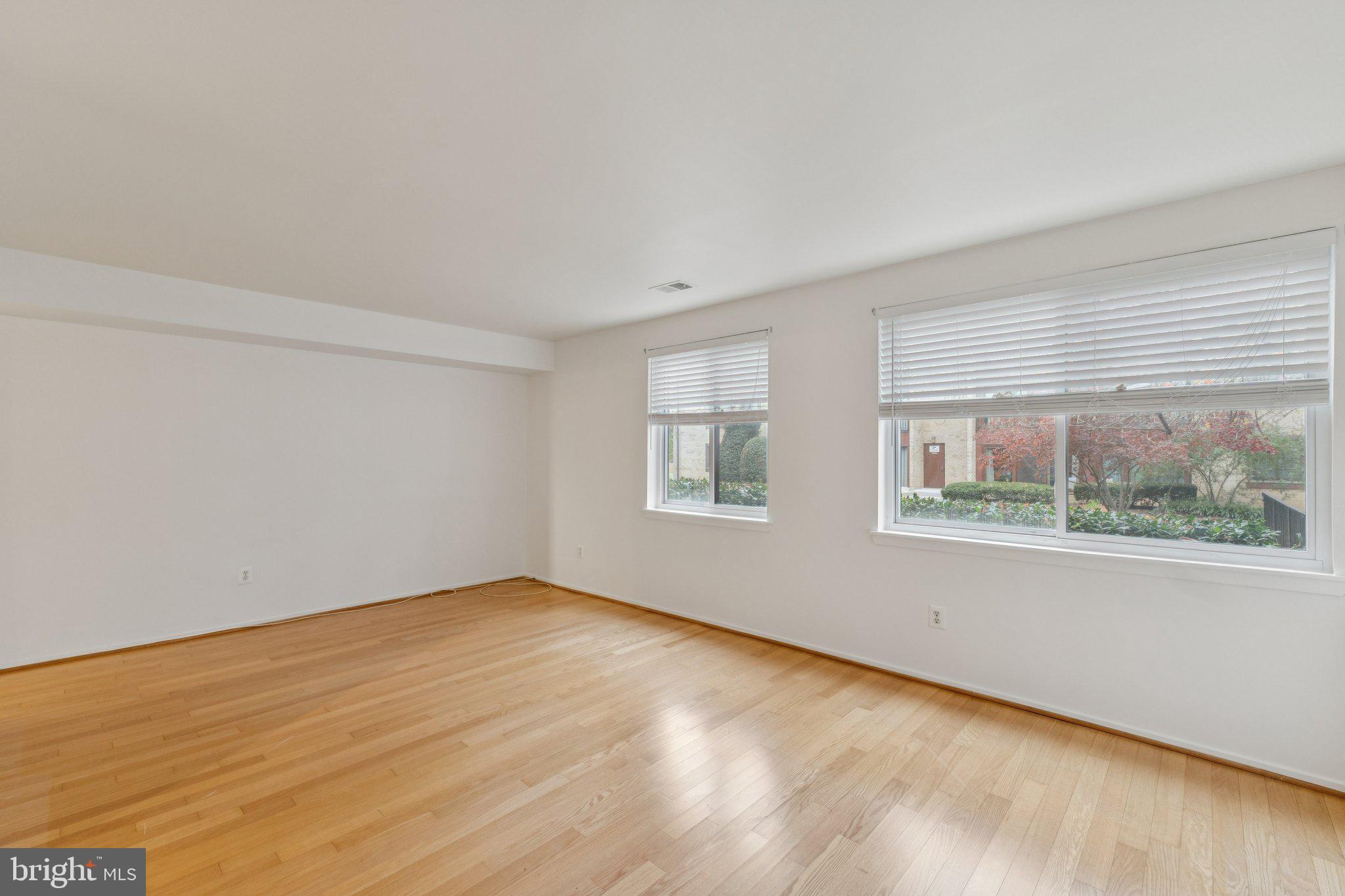 2817 Jermantown Road, Unit 108 Oakton, VA 22124 - Photo 15 of 20 an empty room with wooden floor and windows