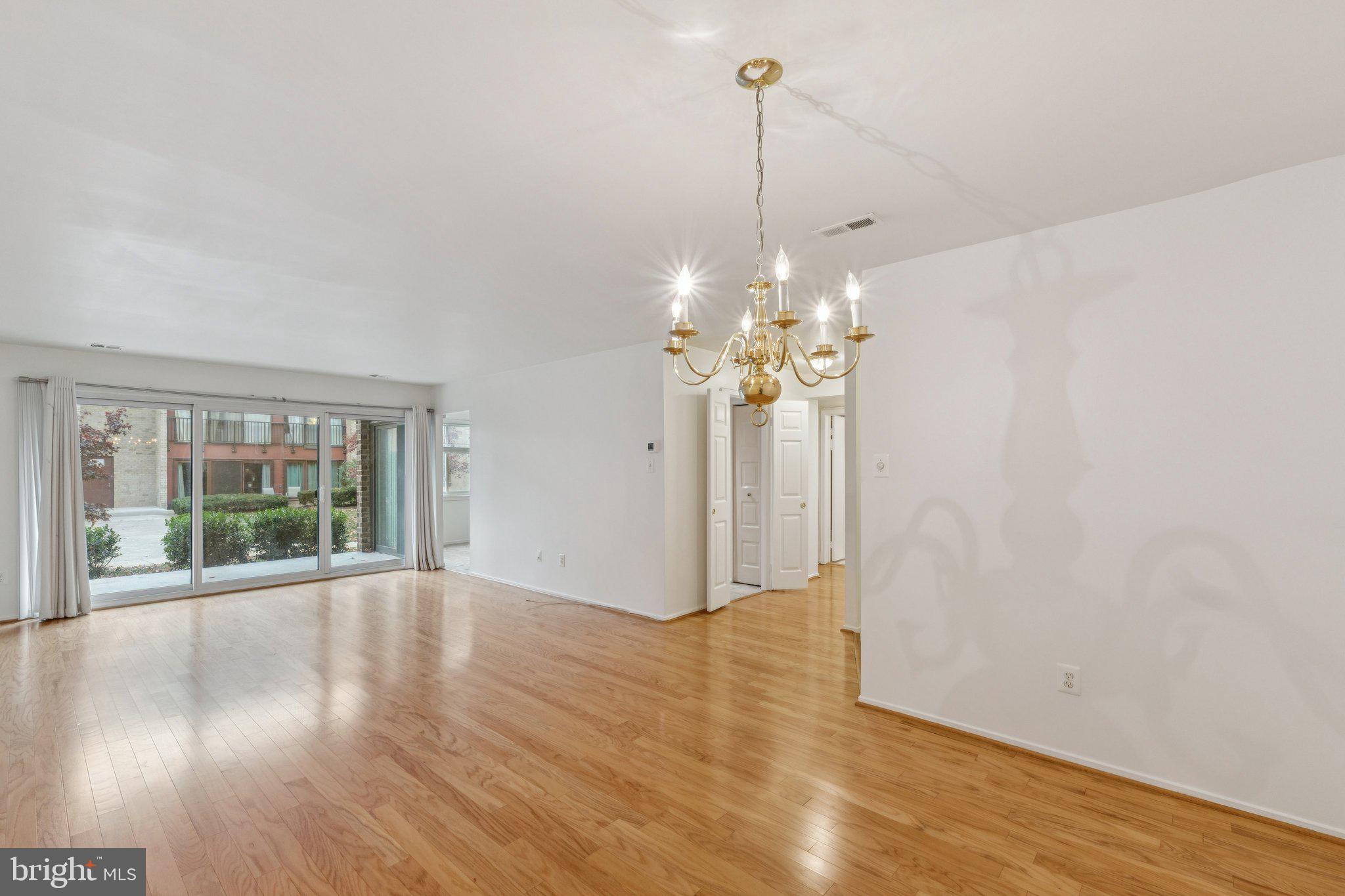 2817 Jermantown Road, Unit 108 Oakton, VA 22124 - Photo 5 of 20 a view of an empty room with wooden floor and a window