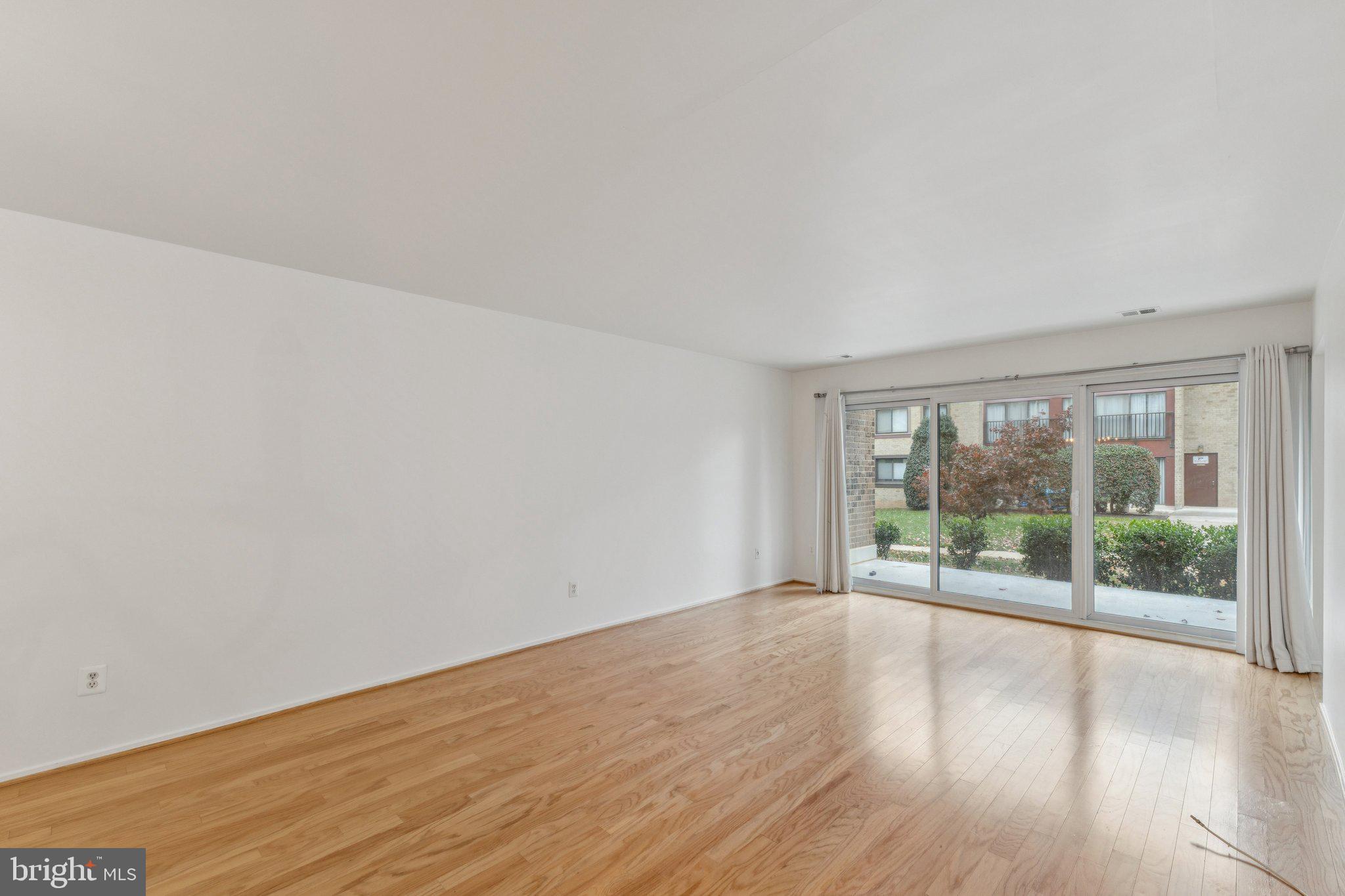 2817 Jermantown Road, Unit 108 Oakton, VA 22124 - Photo 6 of 20 an empty room with wooden floor and windows