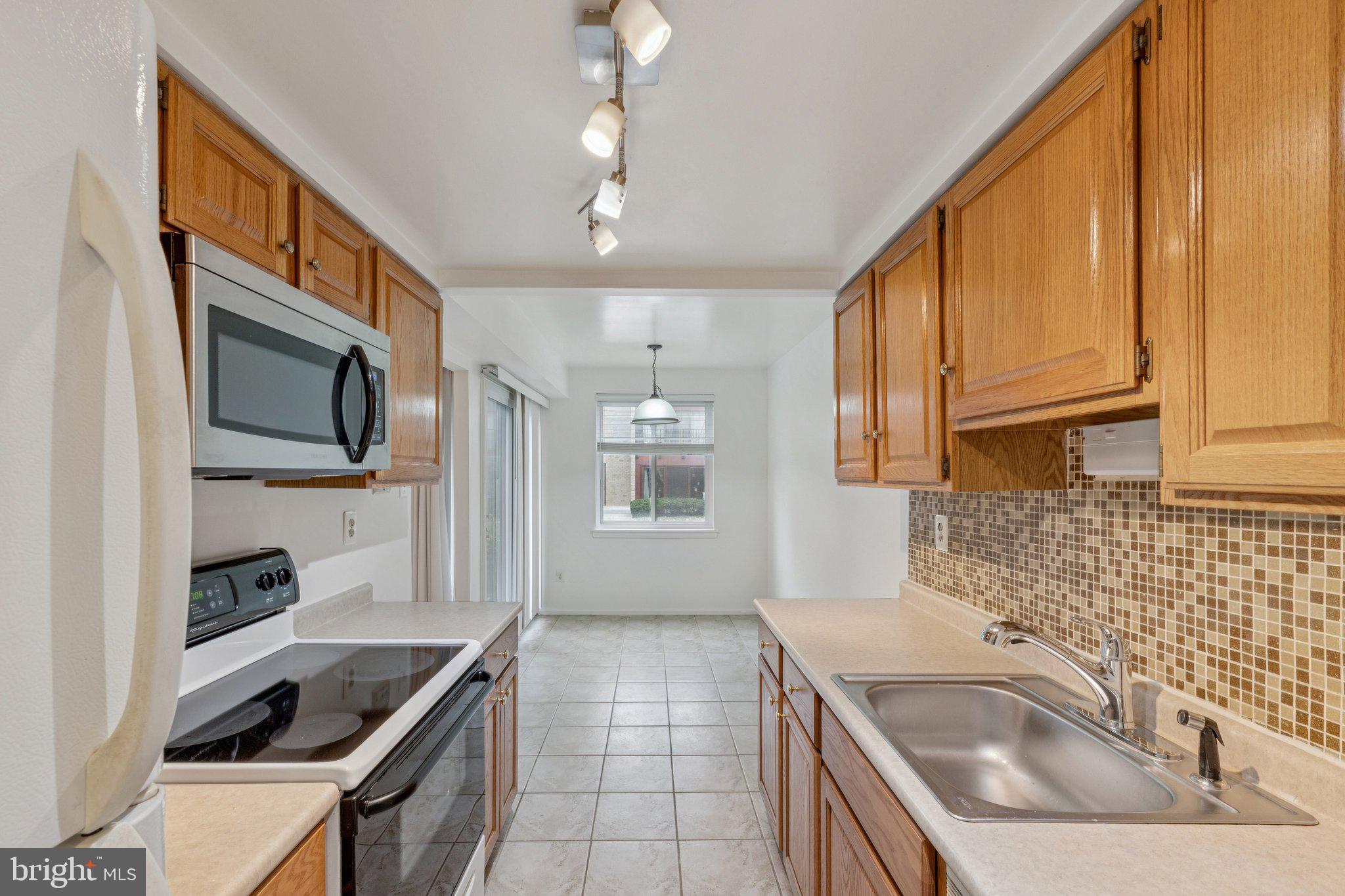 2817 Jermantown Road, Unit 108 Oakton, VA 22124 - Photo 10 of 20 a kitchen that has a sink and a stove top oven
