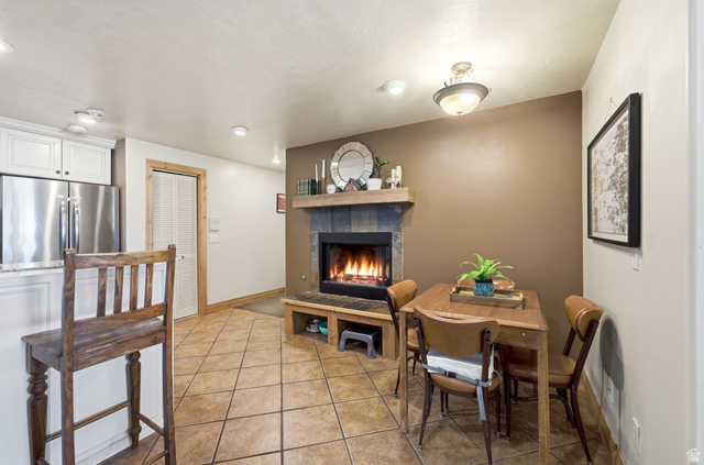 335 Bern Way Midway, UT 84049 - Photo 62 of 88 Ceramic tile flooring extends through this open concept space featuring a stone-clad fireplace with a wood mantle and built-in bench seating