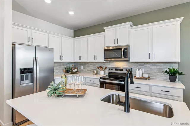 a kitchen with stainless steel appliances a stove a sink and a refrigerator