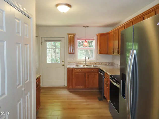 a kitchen with stainless steel appliances granite countertop a refrigerator and a sink