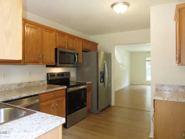 a kitchen with stainless steel appliances granite countertop a refrigerator stove and sink