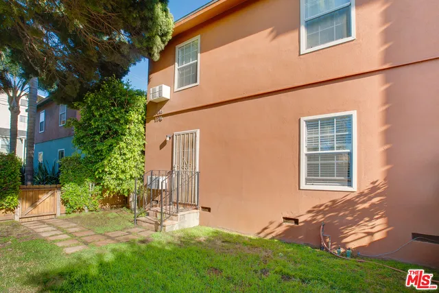 a view of a backyard with plants and large tree