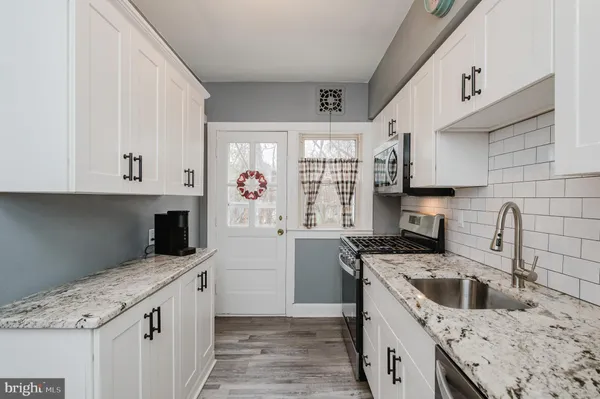 a kitchen with a sink a stove and cabinets