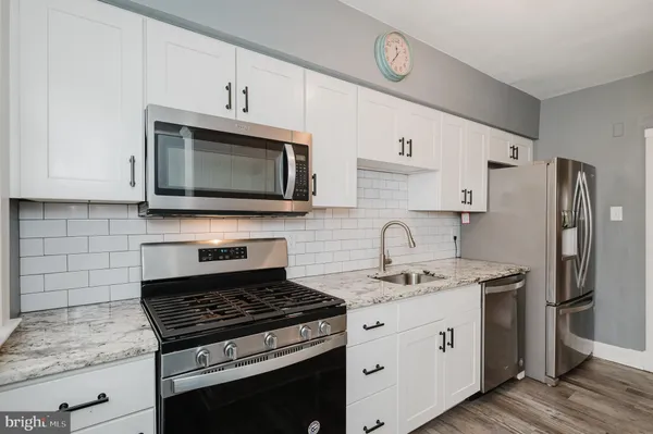 a kitchen with stainless steel appliances granite countertop a stove microwave sink and refrigerator
