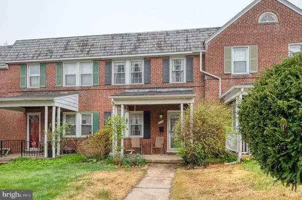 front view of a brick house with a yard